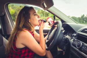 woman putting on make-up behind the wheel