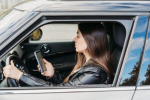 woman using phone while driving