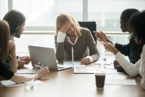 woman being yelled at by a group at work