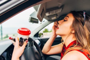 woman putting on makeup while driving